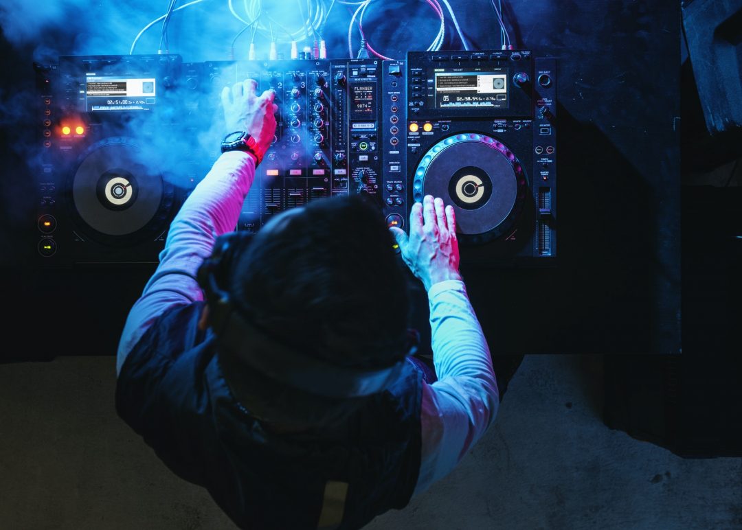 Dj playing music at sound mixer in night club